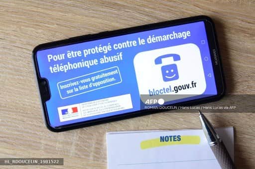 Un téléphone posé sur un bureau affiche la page du service Bloctel invitant à s'inscrire sur la liste d'opposition au démarchage