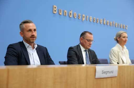 Trois responsables politiques assis à la tribune d'une conférence de presse