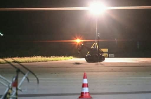Robot démineur de la police sur le tarmac d'un aéroport, de nuit