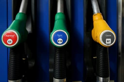 Trois pistolets de pompe à carburant, deux verts pour l'essence et un jaune pour le gazole