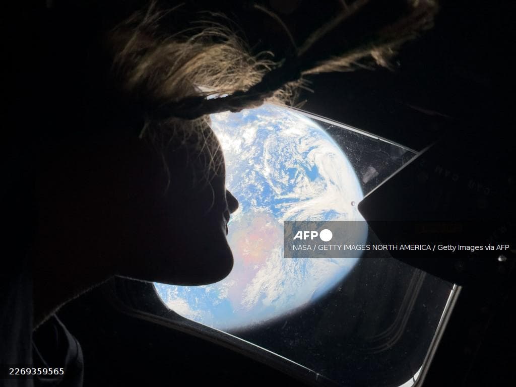 Une astronaute d'Artemis II observe la Terre à travers le hublot du vaisseau Orion en route vers la Lune, avril 2026