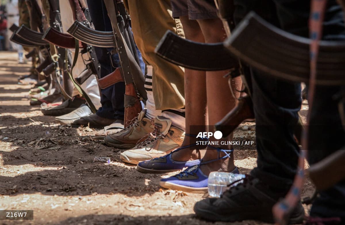 Pieds de jeunes combattants armes de fusils AK-47 illustrant le recrutement d'enfants soldats